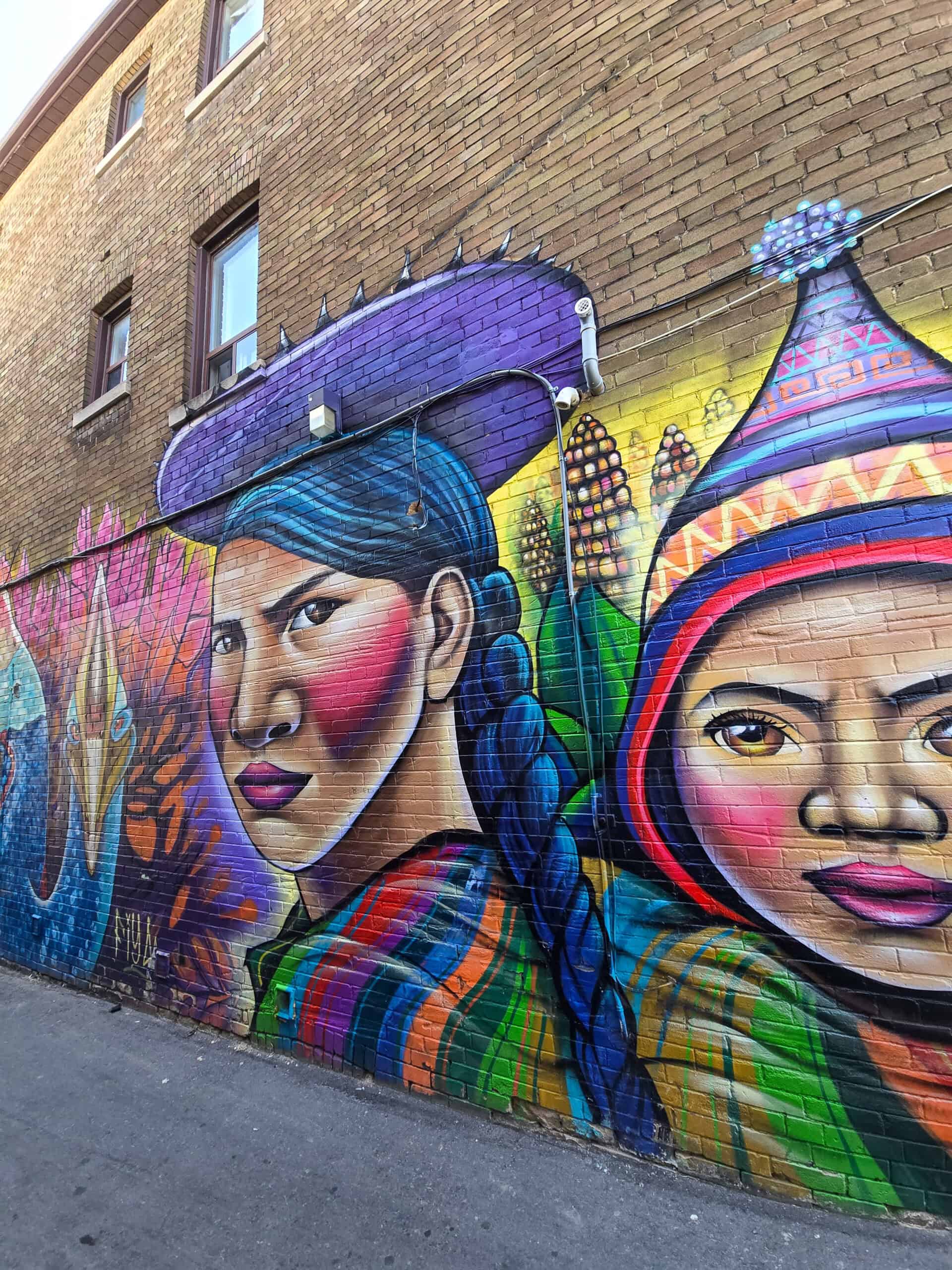 A mural in Little Portugal showing an Indigenous woman and child.