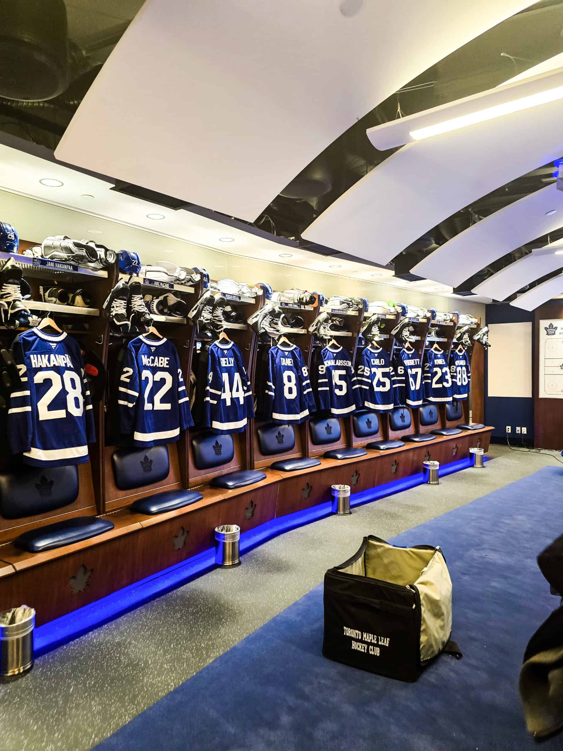 A look inside the Toronto Maple Leafs locker room with player jerseys hanging in a row.